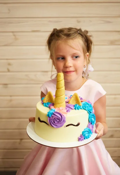 Kız elinde tek boynuzlu at şeklinde pasta tutuyor. — Stok fotoğraf