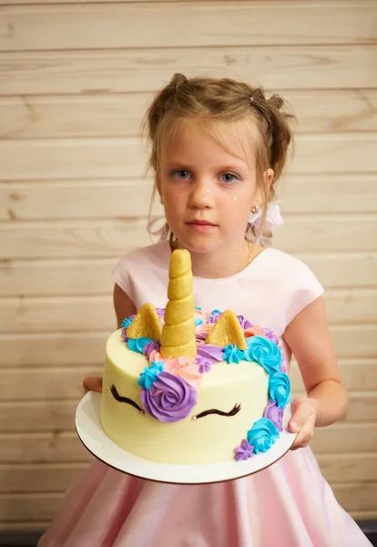 Ragazza che tiene una torta sotto forma di un unicorno — Foto Stock