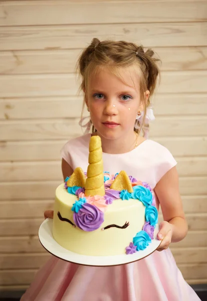Fille tenant un gâteau sous la forme d'une licorne — Photo