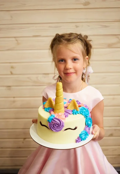 Ragazza che tiene una torta sotto forma di un unicorno — Foto Stock