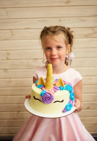 Kız elinde tek boynuzlu at şeklinde pasta tutuyor. — Stok fotoğraf
