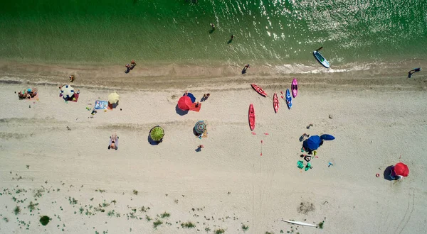 Vista aérea da praia arenosa com turistas nadando em água do mar bonita — Fotografia de Stock