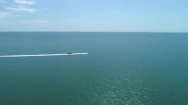 Flight Drone Aerial drone following Banana boat full of people having fun in green sea