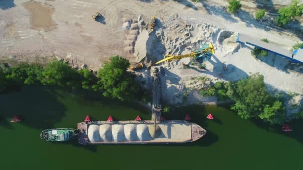La grúa está cargando arena y grava en el barco de la barcaza para el transporte fluvial. Drone aéreo . — Vídeo de stock