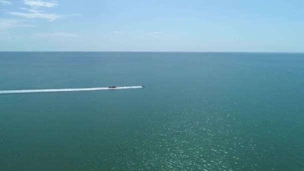 Vuelo Drone Aerial drone siguiendo Banana barco lleno de gente divirtiéndose en el mar verde — Vídeo de stock
