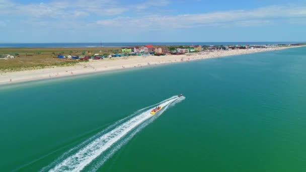 Πτήση Drone Εναέρια drone μετά Μπανάνα βάρκα γεμάτη από ανθρώπους που διασκεδάζουν στην πράσινη θάλασσα — Αρχείο Βίντεο
