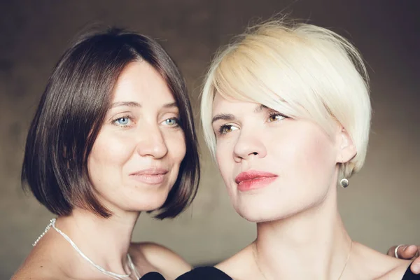 Retrato de dos atractivas mujeres caucásicas sonrientes rubia y morena estudio disparo pelo corto mirando a la cámara . —  Fotos de Stock