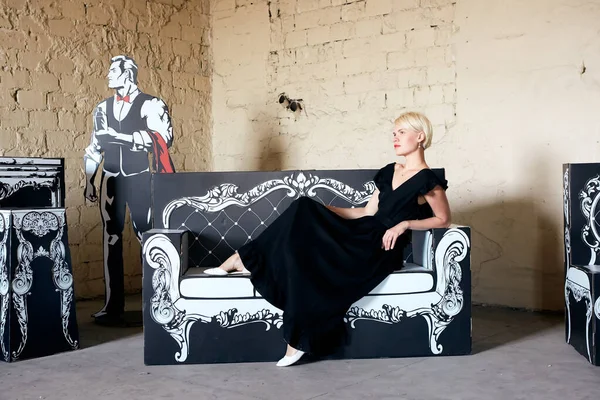 Портрет элегантно красивой молодой женщины, позирующей на картонном антикварном диване . — стоковое фото