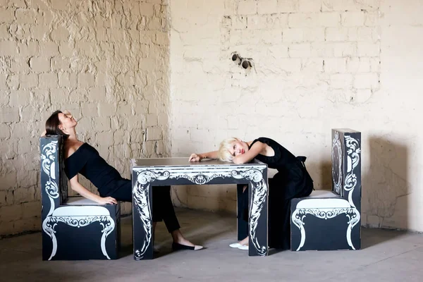Två kvinnor som kopplar av och sitter vid bordet på ett loft café — Stockfoto