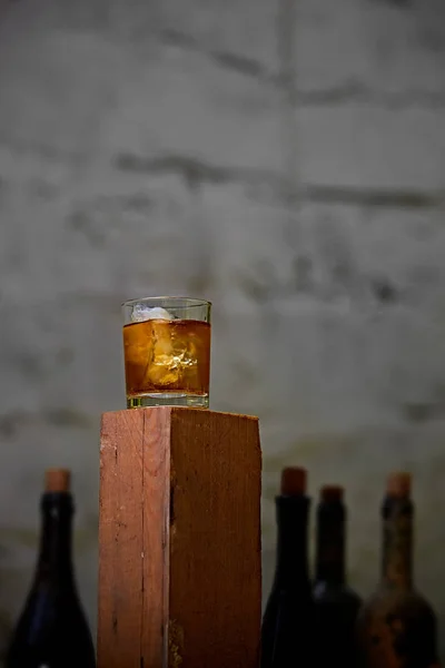 Glas whiskey met ijs op oude houten bar — Stockfoto