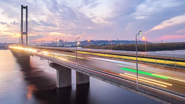 Automobiel- en spoorweg-brug in Kiev, de hoofdstad van Oekraïne. Brug bij zonsondergang over de rivier de Dnjepr. Kiev brug tegen de achtergrond van een prachtige zonsondergang in Kiev. Brug in de avondzon — Stockfoto