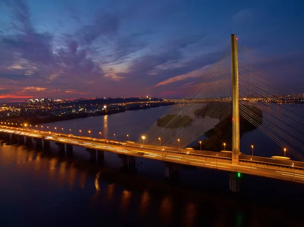 Puente de automóvil y ferrocarril en Kiev, la capital de Ucrania. Puente al atardecer sobre el río Dniéper. Puente de Kiev sobre el telón de fondo de una hermosa puesta de sol en Kiev. Puente en el sol de la noche — Foto de Stock