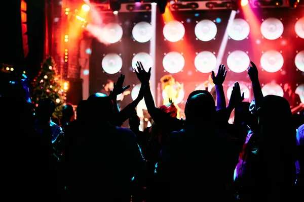 在音乐会上，观众们在明亮的舞台灯光前举手表决. — 图库照片