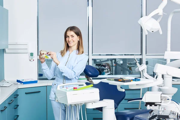 People, medicine, stomatology and healthcare concept - happy young female dentist with tools over medical office background — Stock Photo, Image