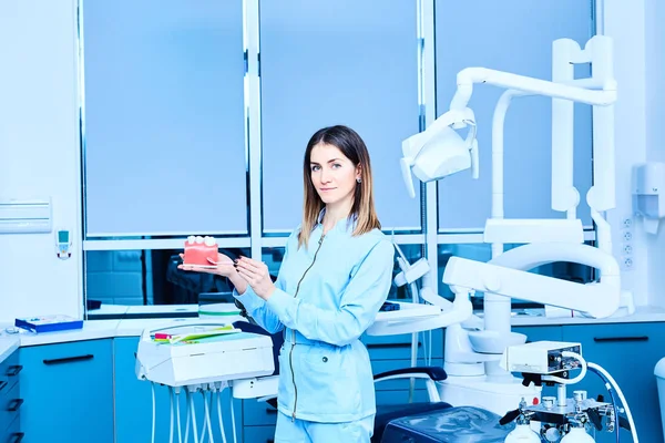 Personas, medicina, estomatología y concepto de salud - joven dentista feliz con herramientas sobre los antecedentes de consultorio médico —  Fotos de Stock