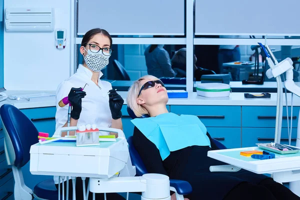 Dentista examinando a una paciente femenina en la clínica —  Fotos de Stock