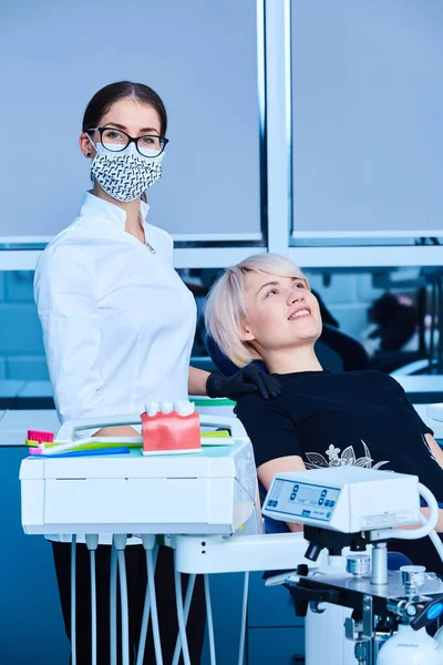 女性のための歯科事務所で患者を検査する女性歯科医. — ストック写真