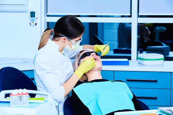 Retrato de uma dentista e uma jovem mulher em um consultório de dentista — Fotografia de Stock