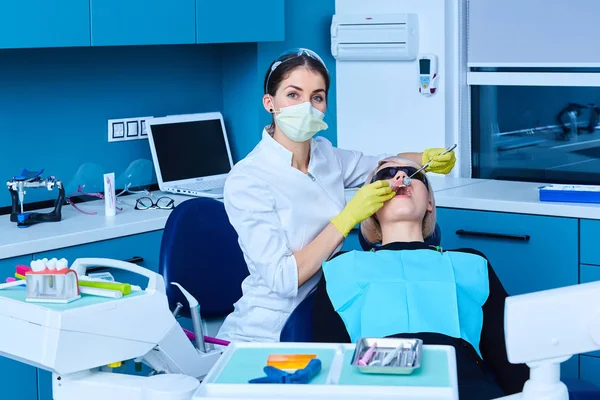 Hermosa paciente que recibe tratamiento dental en el consultorio de dentistas. Mujer visitando a su dentista —  Fotos de Stock