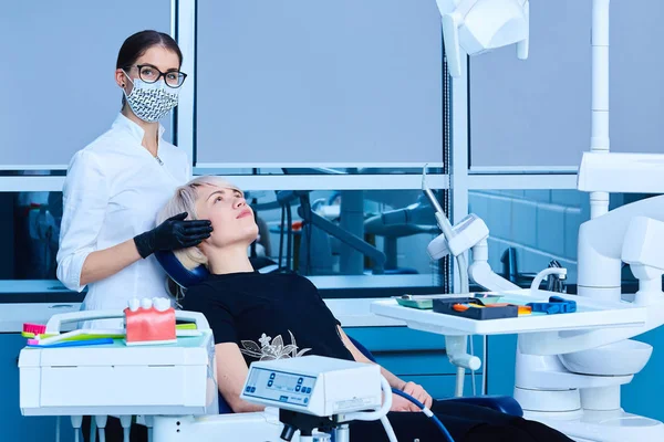 Zahnärztin untersucht eine Patientin in der Zahnarztpraxis für eine Frau. — Stockfoto