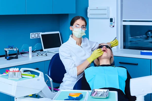 Schöne Patientin mit Zahnbehandlung in der Zahnarztpraxis. Frau zu Besuch beim Zahnarzt — Stockfoto