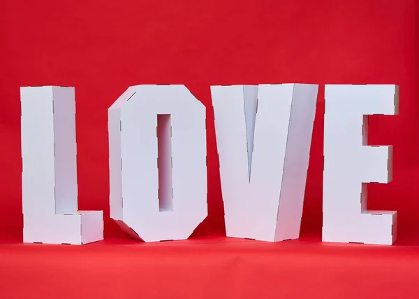 在纸板上写着"爱"这个词是由白色的大字组成的。计划在本季公布. — 图库照片