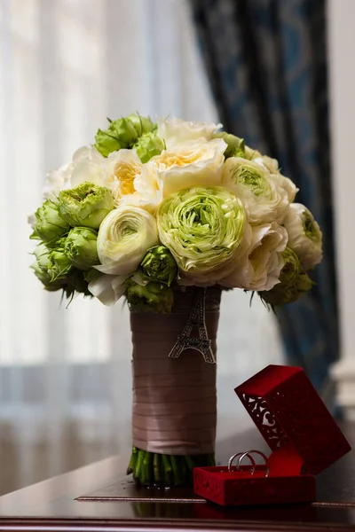Bouquet van witte rozen en zilveren bruiloft ringen. — Stockfoto