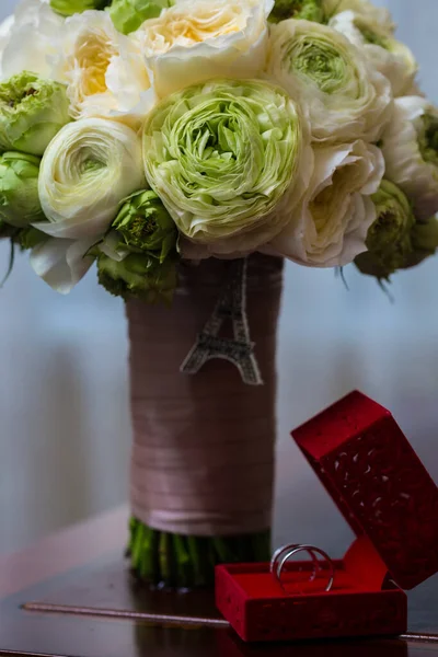 Strauß weißer Rosen und silberne Trauringe. — Stockfoto