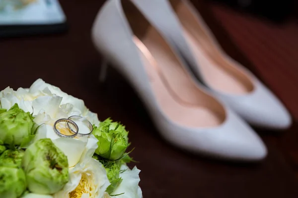 Hochzeitsschuhe und Brautstrauß aus weißen Rosen. — Stockfoto