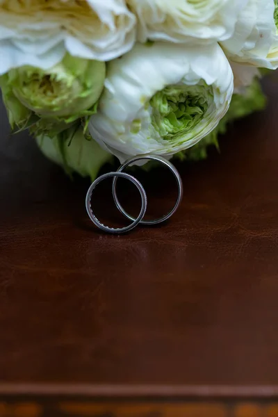 Bouquet of white roses and silver wedding rings. — Stock Photo, Image