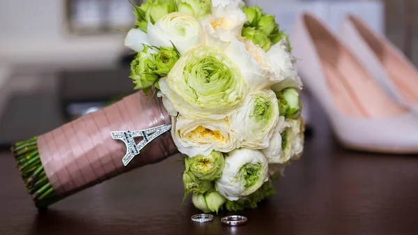Ramo de rosas blancas y anillos de boda de plata . —  Fotos de Stock