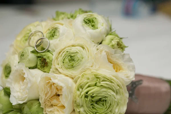 Ramo de rosas blancas y anillos de boda de plata . —  Fotos de Stock