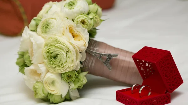 Bouquet van witte rozen en zilveren bruiloft ringen. — Stockfoto