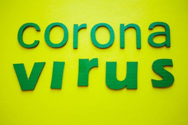 Kelime CORONAVIRUS yeşil karton harflerden yapılmış, sarı arka planda izole. Dünya Sağlık Örgütü WHO, COVID-19 adlı Coronavirus hastalığına yeni bir resmi isim verdi.