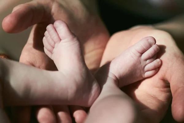 La madre sostiene los pies del bebé recién nacido — Foto de Stock