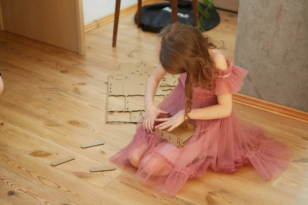 A girl playing with Cardboard Toy Dollhouse Furniture. — Stock Photo, Image