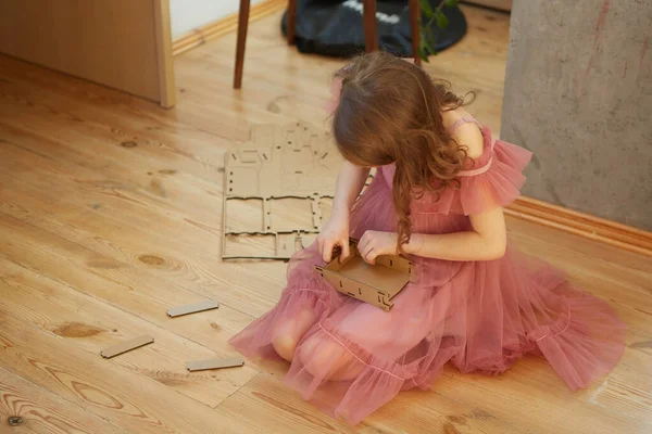 A girl playing with Cardboard Toy Dollhouse Furniture. — Stock Photo, Image