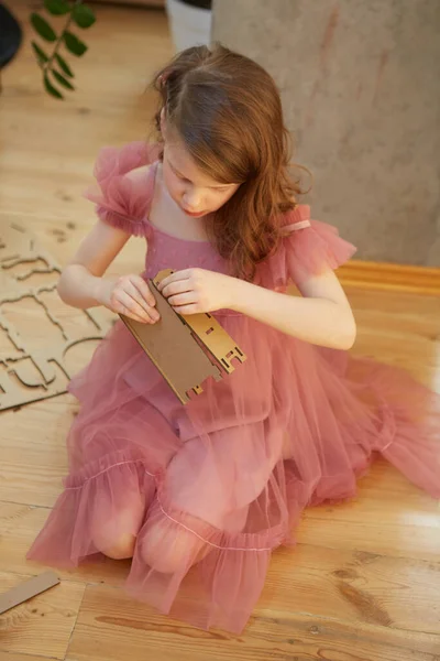 A girl playing with Cardboard Toy Dollhouse Furniture. — Stock Photo, Image