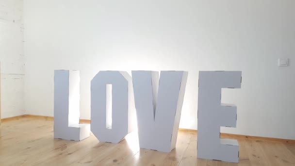 3D Standing Letters formando palabra LOVE de cartón blanco sobre un fondo claro. Concepto de relación — Vídeo de stock