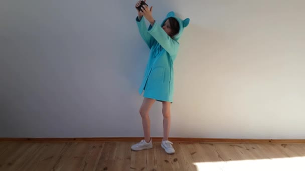 일곱 살된 쾌활 한 어린 소녀가 흰 배경으로 셀카를 만든다. 개념 소셜 미디어 중독 — 비디오