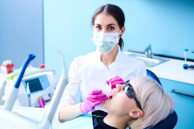 Diş tedavisi diş hekimleri ofiste olan güzel bir kadın hasta. Kadın onun diş hekimi ziyaret