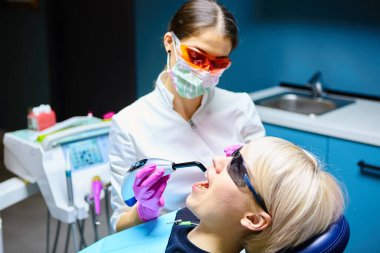 Diş tedavisi diş hekimleri ofiste olan güzel bir kadın hasta. Kadın onun diş hekimi ziyaret