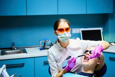 Diş tedavisi diş hekimleri ofiste olan güzel bir kadın hasta. Kadın onun diş hekimi ziyaret