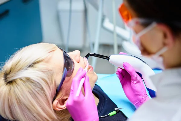 Mulher bonita paciente ter tratamento dentário no consultório odontológico. Mulher visitando seu dentista — Fotografia de Stock