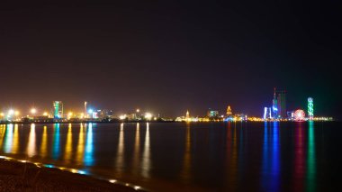 Adjara 'nın başkenti Batumi' deki Karadeniz limanındaki ışıkların gece yansımaları. Georgia.