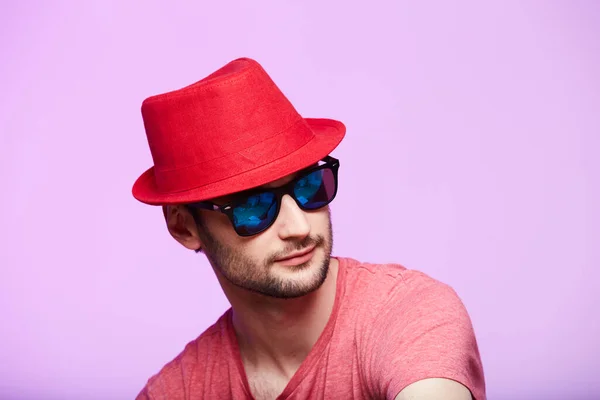 Photo studio d'un bel homme barbu portant un chapeau de fedora rouge . — Photo