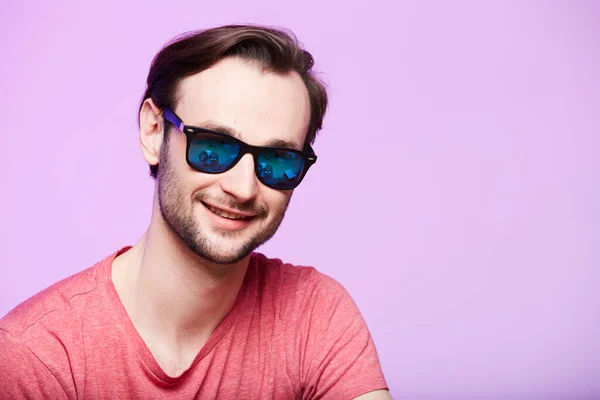 Primer plano retrato de hipster impresionante con gafas de sol con mirada intensa en la cámara. Headshot sobre fondo de estudio rosa . — Foto de Stock