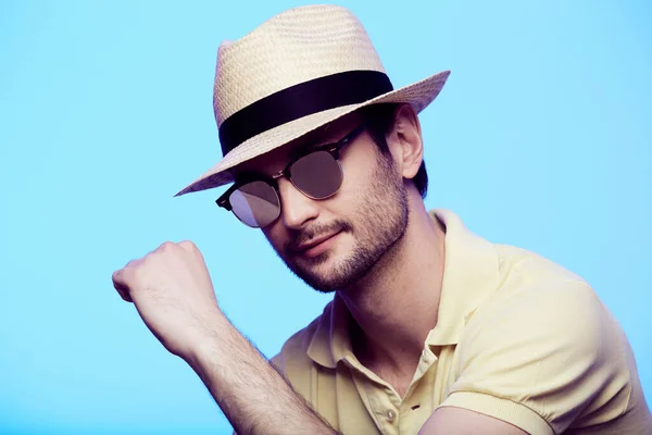 Retrato de primer plano de hipster impresionante con sombrero fedora con mirada intensa en la cámara. Headshot sobre fondo de estudio azul . —  Fotos de Stock