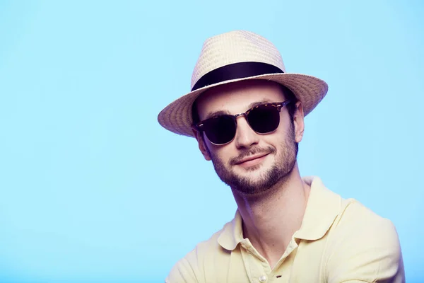 Gros plan portrait de hipster génial portant chapeau fedora avec regard intense à la caméra. Headshot sur fond bleu studio . — Photo