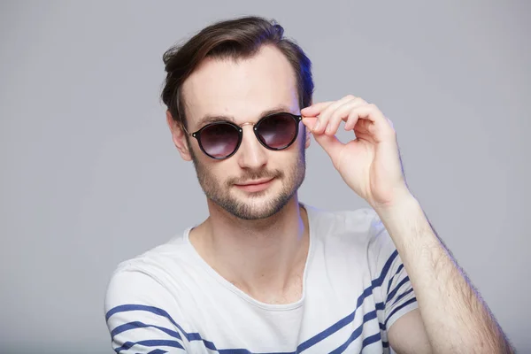 Plan studio d'un bel homme portant des lunettes de soleil — Photo